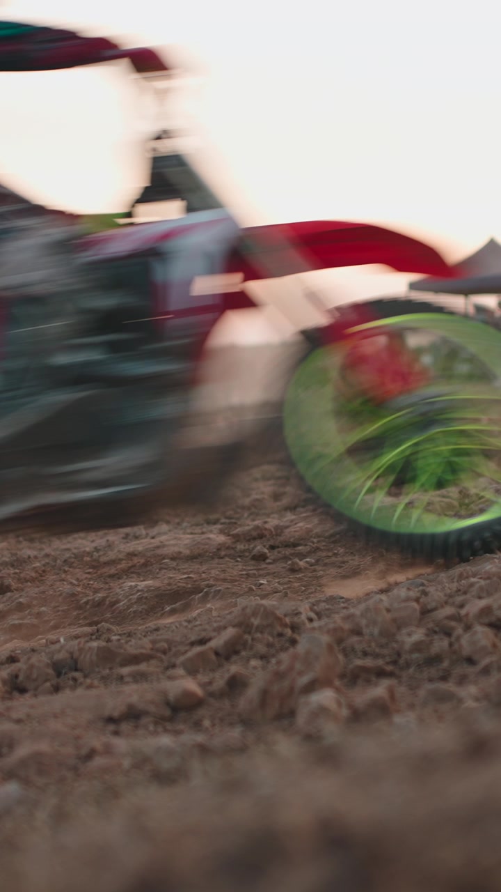 Piloto de motocross correndo em pista de terra ao pôr do sol