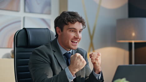 excited winner rejoicing workplace reading great news at laptop closeup. man joy