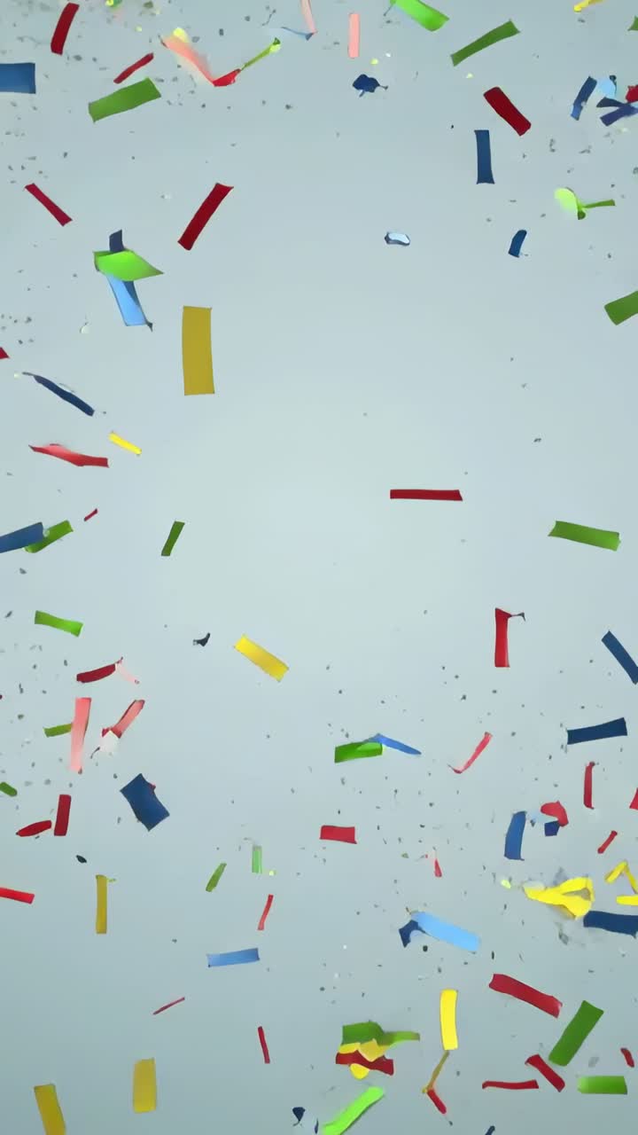 Video verticale: Uno spruzzo bianco fuori campo che fa fluttuare coriandoli e pezzetti di carta stagnola sopra lo studio per la ripresa.