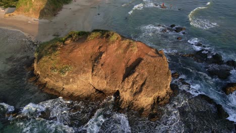 drone slowly approaching a giant rock at playa grande in tamarindo, costa rica