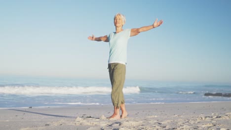 Mujer-Caucásica-Mayor-Disfrutando-Del-Tiempo-En-La-Playa-Con-El-Mar-Al-Fondo