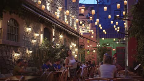 traditional greek taverna at night, mytilene bar and cafe nightlife with people enjoying drinks and communication, handheld gimbal shot