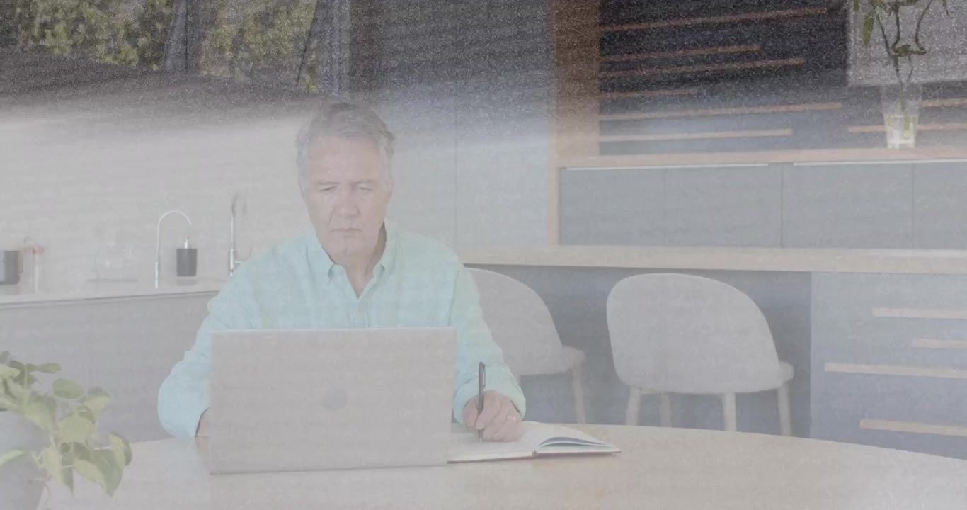Man placing laptop and taking business notes in kitchen, band often sweeping then clearing screen