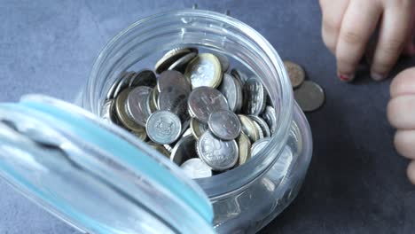 child saving money in a glass jar