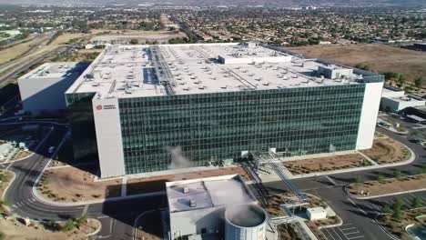 a large, modern technology facility stands prominently in an industrial area, demonstrating cutting-edge architecture. the surrounding landscape features urban elements and open spaces.