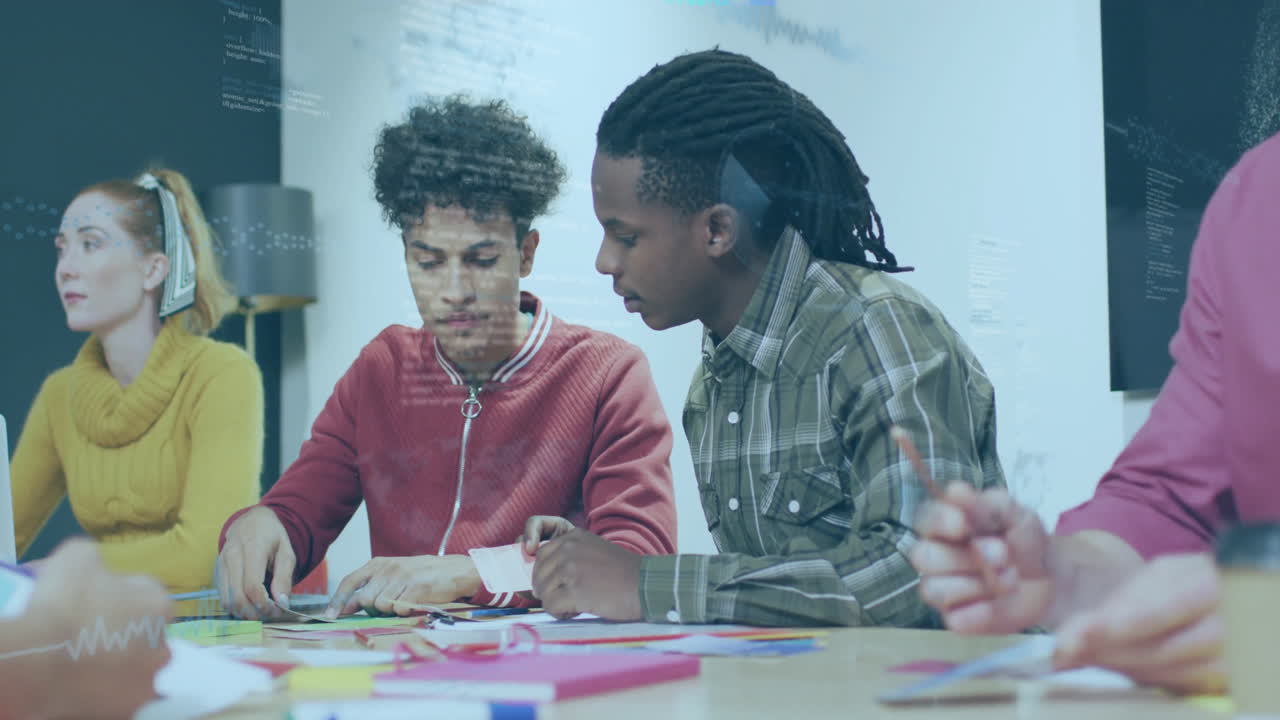 In school, diverse group collaborating on creative animation project at table