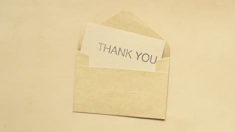 thank you message and envelope on wooden table