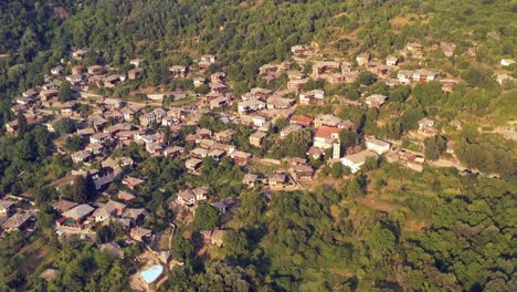 disparo aéreo lento sobre antiguas casas de pueblo de montaña e iglesia de kovachevitsa rhodopes bulgaria