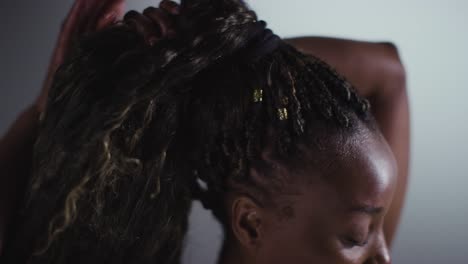 close up studio beauty shot of woman putting up hair 1