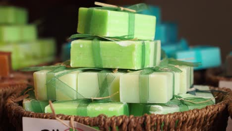 stack of handmade green soap bars in wicker basket