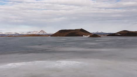 zoom-in view of frozen lake mývatn with volcanic craters in skútustaðir, reykjahlíð, iceland.