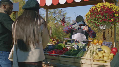 elderly farmer with bushy mustaches packs bananas elderly farmer with bushy mustaches packs bananas in eco bag african american man pays off by cash multi ethnic family shopping at local farmers market vegetarian and organic food agriculture