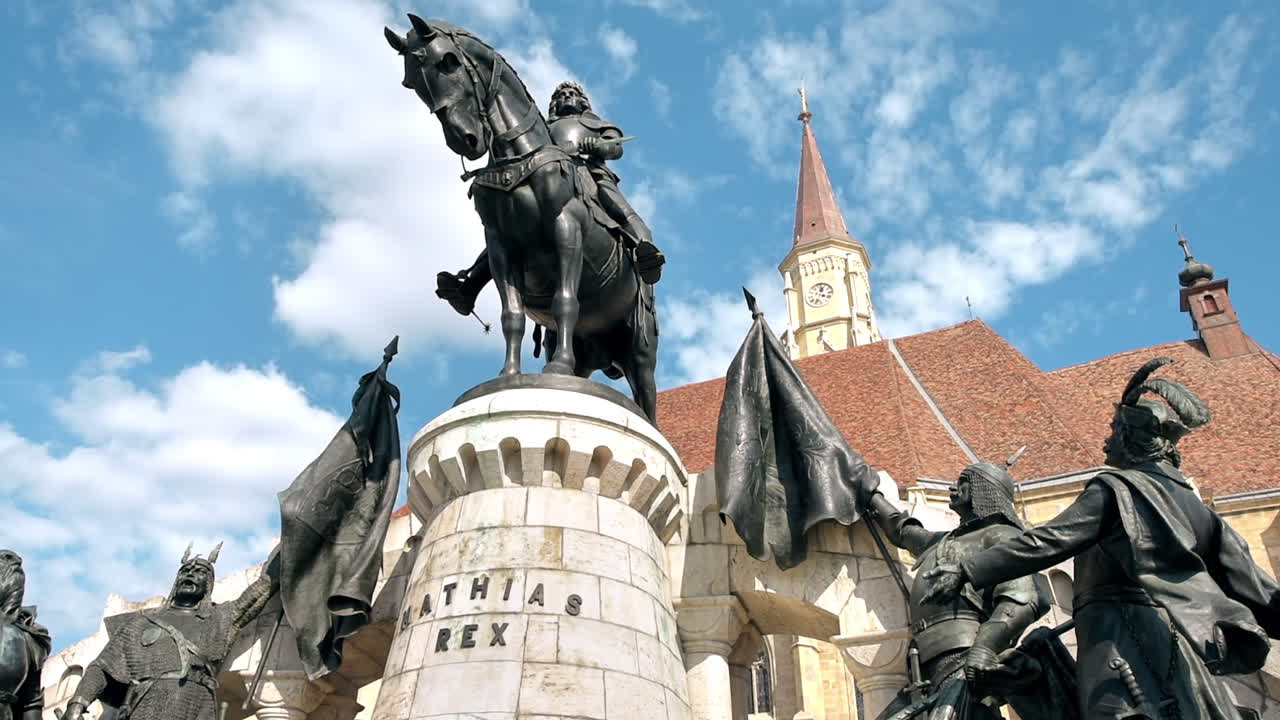 Paesaggio urbano del centro di Cluj, Romania. Piazza centrale con la Chiesa di San Michele e la statua di Mattia Corvino di fronte.