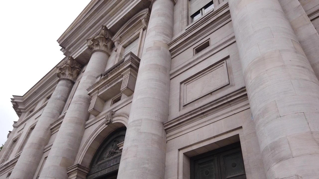 Primo piano dell'architettura dell'Edificio della Banca Nazionale: colonne neoclassiche, archi, porta