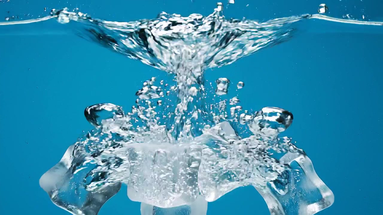 Ice cubes splashing into clear blue water with bubbles