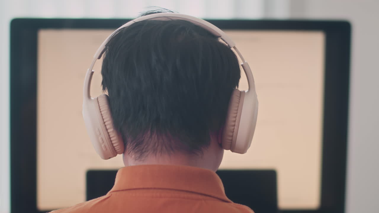 Male Coder in Headphones Working on Computer
