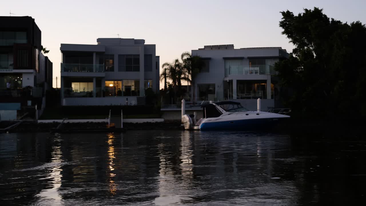 A boat moves along a canal at dusk