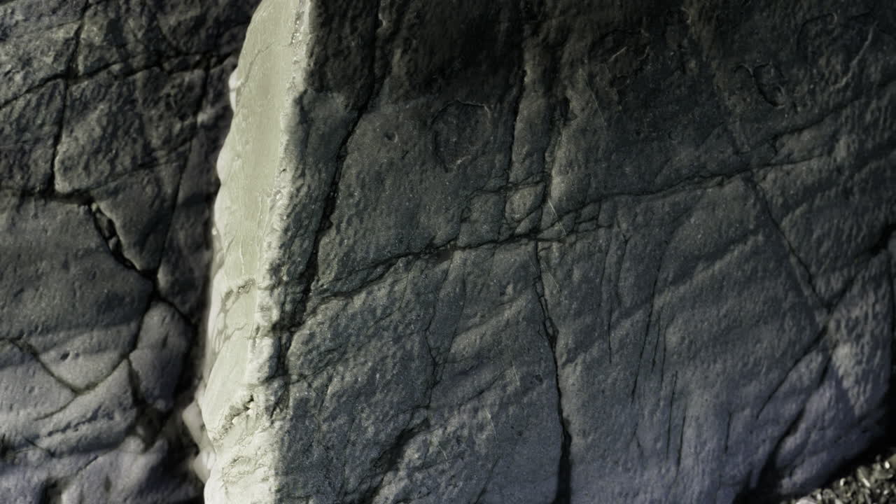 Natural rock formation showcasing intricate textures and shadows in soft light