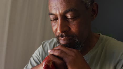 Close-up-of-african-american-man-holding-a-walking-stick-at-home