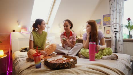 chicas adolescentes disfrutando de pizza y conversación en un dormitorio acogedor