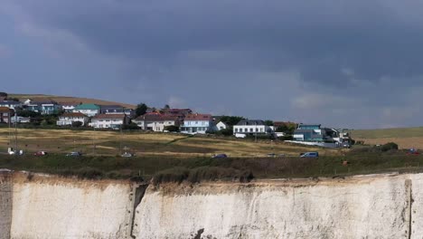 Toma-Aérea-De-Turistas-Que-Usan-La-Carretera-Costera-A259-Cerca-De-Brighton,-Reino-Unido,-Con-Sus-Infames-Acantilados-Blancos