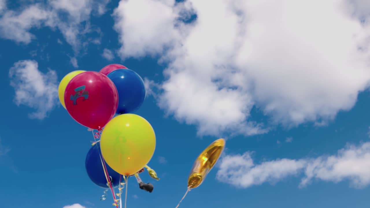 Beautiful view of festive balloons for child developing in  wind against blue sky with white clouds. Sweden.