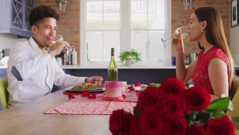 happy biracial couple having valentine's day celebration meal at home