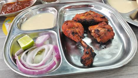 succulent chicken tandoori grilled in a clay oven, paired with special sauce and onions. a flavorful indian dish with rich spices and an irresistible aroma.