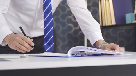 close-up of a businessman's hands signing a contract in a modern workplace.