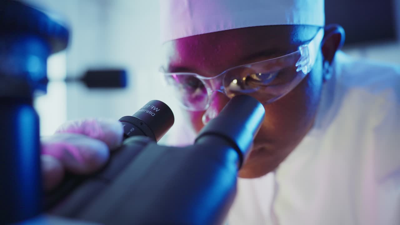 Primo piano di scienziato che osserva al microscopio in laboratorio
