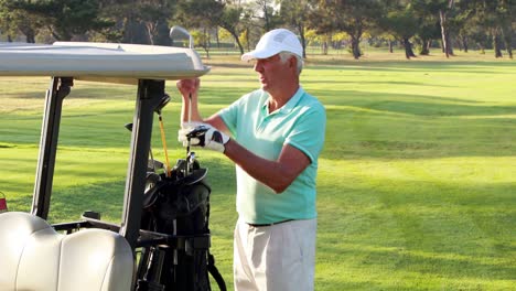 male golfer removing golf club from golf bag