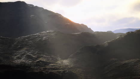 sunlight breaks over rugged mountain terrain in a breathtaking landscape