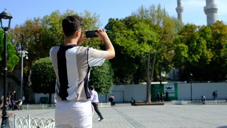 young man taking pictures in sultanahmet square