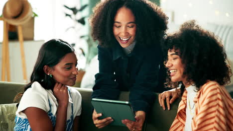three women looking at a tablet