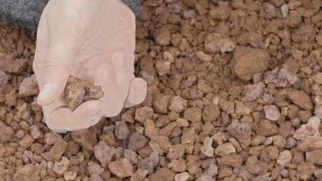 close-up of a woman's hand sensually playing with volcanic gravel