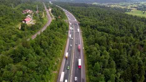 Wunderschöne-Autobahn-In-Einem-Grüngürtel-Mit-Hohen-Bäumen-Und-Einer-Eisenbahnlinie-Daneben-Und-Einer-Überführung-Irgendwo-In-Europa
