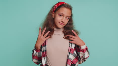 cheerful lovely young teenager child girl kid smiling, looking at camera on studio blue background