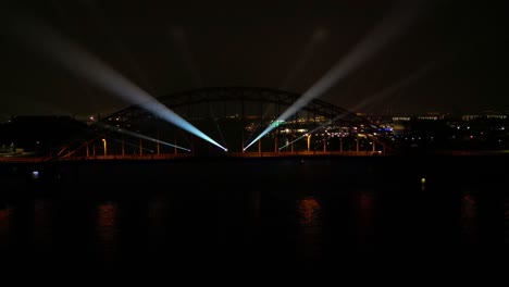 vista nocturna con espectáculo de luces en un puente colgante de acero sobre el río noord en hendrik-ido-ambacht en holanda