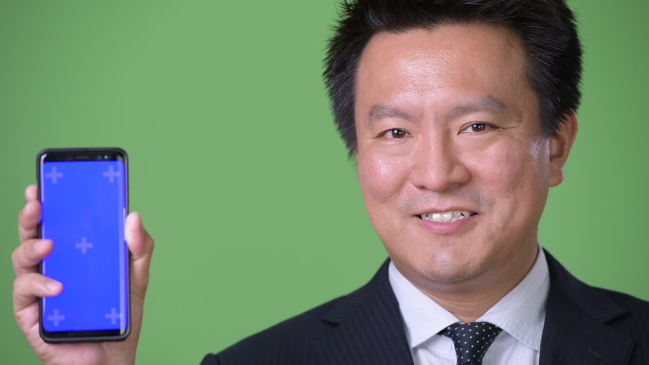 녹색 배경에 성숙한 일본 사업가