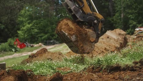 excavator bucket picking up and dumping dirt