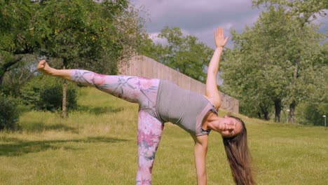 Mujer-Caucásica-Tiene-Pose-De-Yoga-Lateral-En-La-Naturaleza,-Inclinación-De-Cámara-Lenta