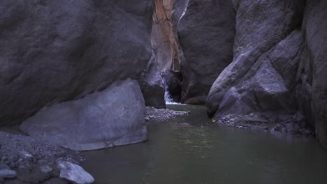 small secluded waterfall between high cliffs