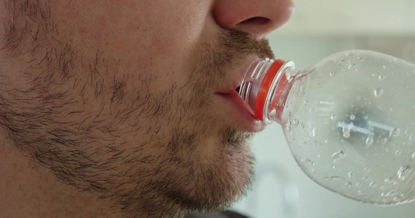 Homem bebendo água de uma garrafa e arrotando em seguida. Adequado para azia, refluxo ácido, indigestão, desconforto digestivo, saúde gastrointestinal, hidratação e conceitos de saúde.