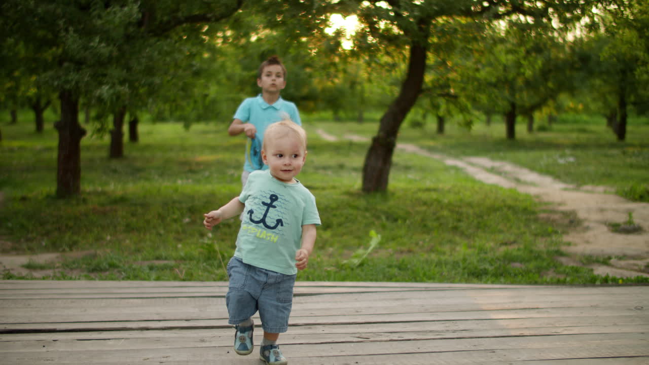 Cute brothers playing in summer park. Smiling siblings spending time together