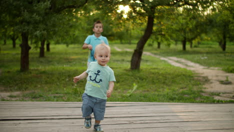 Cute-brothers-playing-in-summer-park.-Smiling-siblings-spending-time-together