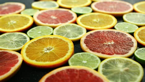 Slices-of-citruses-on-dark-table-