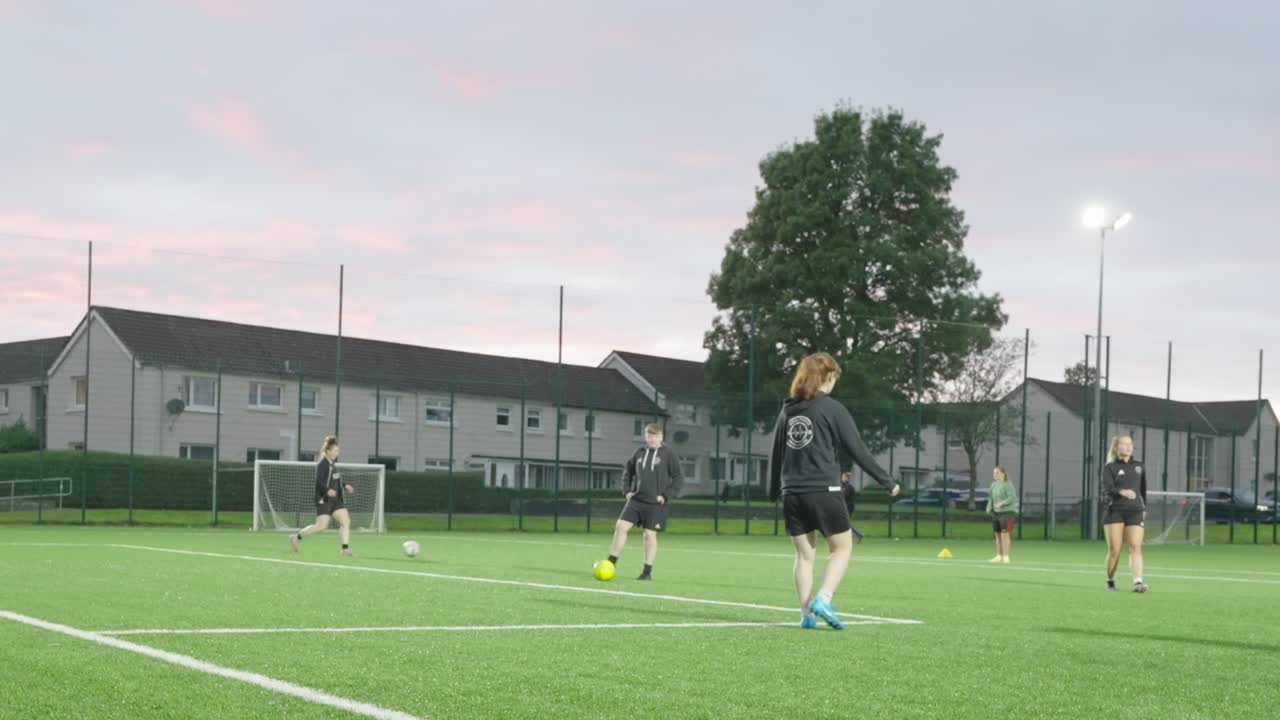 Small group, football female players, teammates training, evening scene