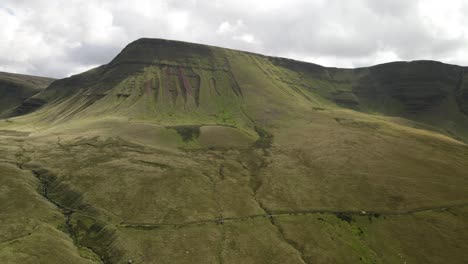 Idyllic-Brecon-beacons-national-park-llyn-y-fan-fach-mountain-range-aerial-dolly-left-view-across-rolling-valley