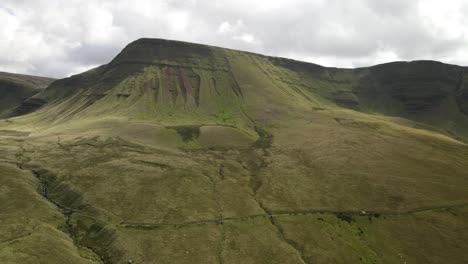 Idílico-Parque-Nacional-De-Brecon-Beacons-Llyn-Y-Fan-Fach-Cordillera-Aérea-Dolly-Vista-Izquierda-A-Través-Del-Valle-Ondulado