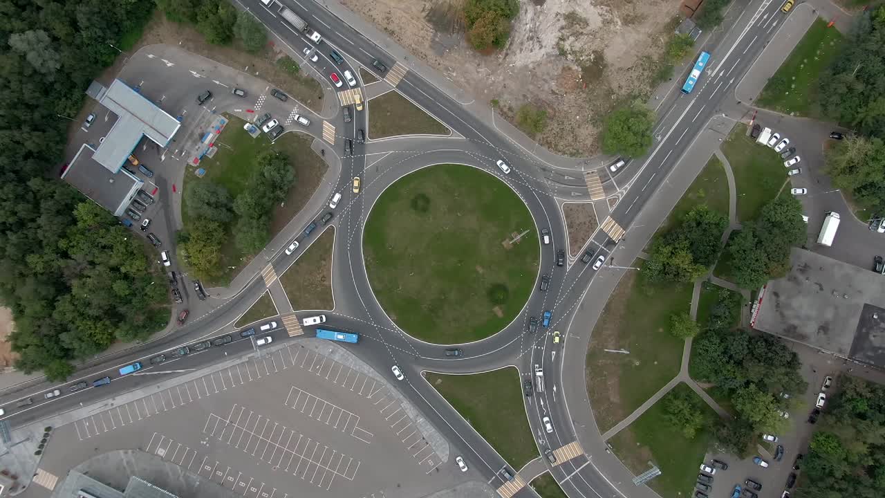 vista aérea del tráfico de automóviles en una rotonda en la gran ciudad. vuelo de drones de arriba hacia abajo en espiral